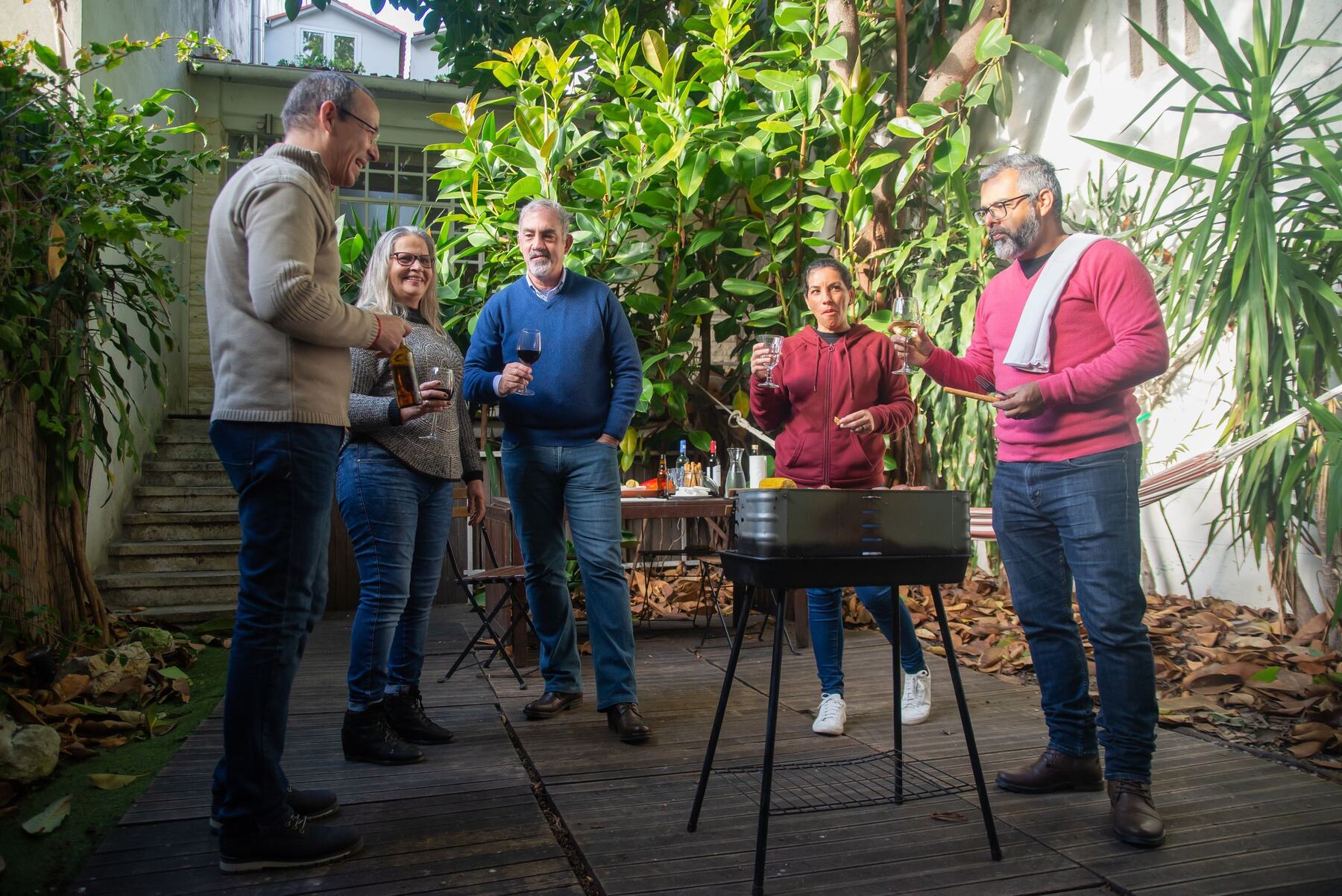 Neighbors gathered around a grill in a shared garden
